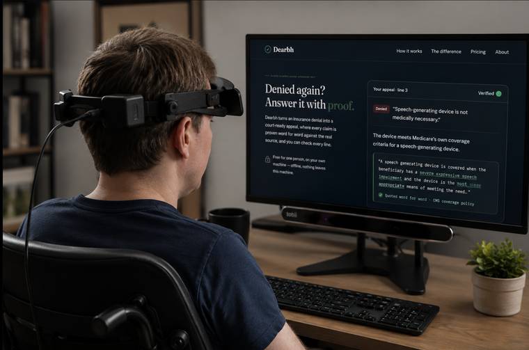 Dearbh’s founder at his desk in a wheelchair, wearing a head-mounted eye-tracking device, using Dearbh on screen through a Tobii tracker.